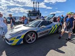 olicejní supersport Ferrari 458 Italia v barvách Policie ČR na statické ukázce na Dnech NATO v Ostravě 2025 obklopený návštěvníky.